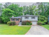 Charming two-story home with a well-manicured lawn and mature trees surrounding the property at 3664 Satellite Ter, Ellenwood, GA 30294
