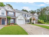 Inviting two-story townhome featuring a well-maintained lawn and attached one car garage at 3022 Kentmere Dr, Cumming, GA 30040