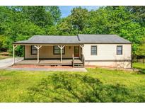Charming single-story home with a welcoming front porch and well-maintained lawn at 6182 Silver Spur Dr, Lithonia, GA 30058