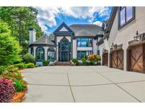 Stunning home features a large driveway, three-car garage, and professionally landscaped yard at 1114 Waterford Green Pt, Marietta, GA 30068