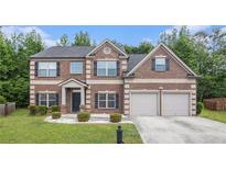 Charming two-story brick home with a well-manicured lawn and a two-car garage at 3225 Rex Ridge Dr, Rex, GA 30273