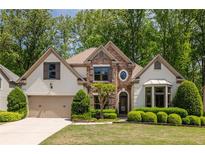 Charming home with a manicured lawn, beautiful landscaping, and a stone-accented facade at 150 Park Creek Dr, Alpharetta, GA 30005