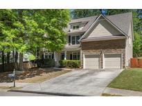 Inviting two-story home featuring a two-car garage, landscaped yard and traditional architectural details at 6330 Beaver Crossing Dr, Cumming, GA 30040
