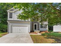 Charming two-story home features a two-car garage, stone accents, and a well-maintained front yard at 110 Slate Ridge Ln, Loganville, GA 30052