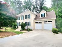 Charming two-story home with a two car garage, green shutters, and beautifully landscaped front yard at 2980 Milford Sw Trl, Marietta, GA 30008