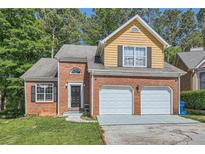 Charming brick home featuring a two-car garage and manicured lawn, offering great curb appeal at 3812 Maclaren Dr, Clarkston, GA 30021