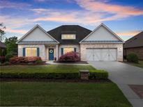 Charming one-story brick home with a well-manicured lawn and blue shutters offers a welcoming curb appeal at 4815 Amble Trce, Cumming, GA 30040