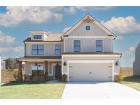 Two-story home featuring gray siding, a two-car garage, and a well-manicured lawn at 4140 Chapel Hill Reserve, Douglasville, GA 30135