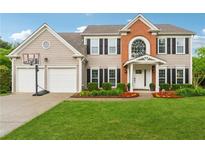 Charming two-story home with a well-manicured lawn, two-car garage, and a classic brick facade at 7545 Brookwood Way, Cumming, GA 30041