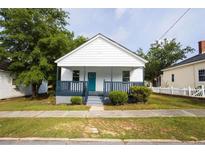 Charming single-story home featuring a quaint porch and beautifully maintained front yard at 27 Hazel St, Porterdale, GA 30014