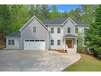 Beautiful two-story home with a manicured lawn, attached garage and inviting front porch at 552 Steels Bridge Rd, Canton, GA 30114
