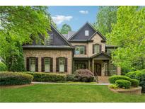 Charming brick home featuring lush landscaping, a well-manicured lawn, and a welcoming front porch at 2551 Raintree Ne Dr, Atlanta, GA 30345