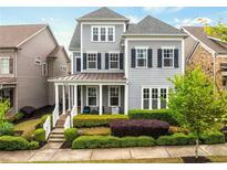Charming two-story home with gray siding, manicured landscaping, and a welcoming front porch at 4020 Declaration Dr, Roswell, GA 30076
