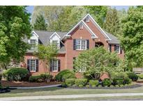 Charming brick home with black shutters, manicured landscaping, and mature trees at 3284 Bakers Mill Ct, Dacula, GA 30019
