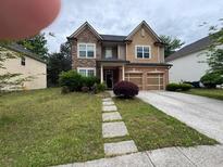 Charming two-story home features a well-manicured lawn and a two car garage at 4341 Savannah Ln, Atlanta, GA 30349