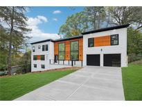 Modern two-story home featuring a concrete driveway, two-car garage, and eye-catching architectural details at 2396 Sunset Ne Dr, Atlanta, GA 30345