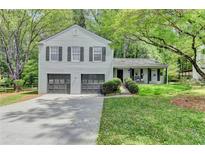 Charming two-story home with a two-car garage, landscaped yard, and covered front porch at 655 Barrington Way, Roswell, GA 30076