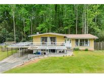 Unique home with a large deck and carport, nestled in a lush, wooded setting, providing privacy at 1188 Cedar Park Cir, Stone Mountain, GA 30083