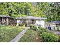 Charming bungalow with a landscaped front yard and inviting front porch, surrounded by mature trees at 261 Hemphill School Nw Rd, Atlanta, GA 30331