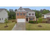 Charming two-story home featuring a brick facade and well-manicured front yard at 3510 Meadow Grass Dr, Dacula, GA 30019