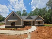 Charming new construction featuring stone accents, gray siding, and a welcoming walkway to the front door at 879 Highway 101 N, Dallas, GA 30157