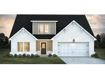 Charming one-story home featuring a white brick exterior, a dark roof, and a two-car garage, surrounded by a green lawn at 330 Orwell Dr, Social Circle, GA 30025