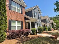 Charming townhomes featuring brick and siding exteriors, complemented by lush landscaping and inviting walkways at 487 Cypher Dr, Suwanee, GA 30024