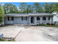 Ranch style home with gray brick porch and large driveway at 535 Transit Cir, Atlanta, GA 30349