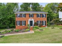 Charming two-story brick home with black shutters and a beautifully landscaped front yard at 682 Leighton Way, Stone Mountain, GA 30088