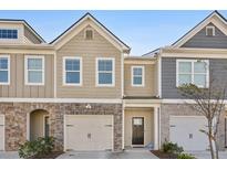 Charming townhome with a two-car garage and neutral siding, with a stone and brick accent at 5853 Greystone Dr, Lithonia, GA 30058