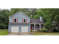 Charming two-story home with a two-car garage, red shutters, and mature trees in the front yard at 3236 Grove Nw Trl, Acworth, GA 30101