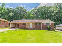 Charming brick ranch home with a well-manicured lawn and mature trees at 2311 Cherry Blossom Sw Dr, Atlanta, GA 30331