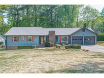 Charming home with a well-manicured lawn, blue siding and red shutters at 554 Cana Of Galilee Ct, Tucker, GA 30084