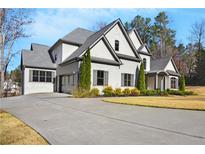Charming two-story home featuring a long driveway and a three car garage, set on a well-manicured lawn at 4370 Freys Farm Nw Ln, Kennesaw, GA 30152