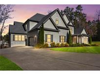 Beautiful grey two-story home featuring manicured landscaping and a spacious driveway leading to a two-car garage at 4370 Freys Farm Nw Ln, Kennesaw, GA 30152
