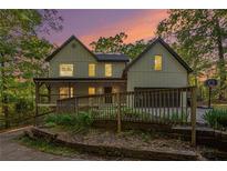 Charming two-story home with a welcoming front porch and well-maintained landscaping at sunset at 4614 Riveredge Cv, Snellville, GA 30039