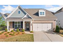 Charming brick and siding home with a two-car garage and inviting front porch seating area at 503 Forest Ln, Canton, GA 30114