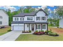 Inviting two-story home with a two-car garage, white painted brick, complemented by dark brown shutters and trim at 3180 Andover St, Cumming, GA 30028