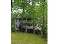 Two-story home with a gray exterior featuring double porches framed by mature trees at 3876 Winners Ct, Marietta, GA 30062