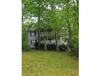 Two-story home nestled among mature trees with a large porch at 3876 Winners Ct, Marietta, GA 30062
