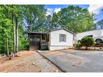 Charming home with a cozy screened porch nestled among mature trees at 164 Chickasaw Ln, Austell, GA 30168