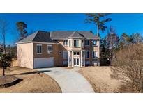 Charming home with a large front yard and driveway leading up to the attached garage at 4197 Trotters Way Dr, Snellville, GA 30039