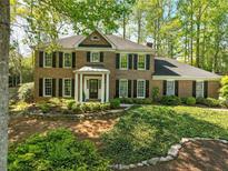 Charming brick home featuring a manicured front yard and mature trees at 5452 Tally Green Dr, Marietta, GA 30068