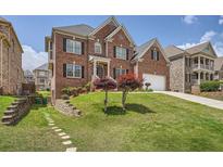 Traditional brick home with a manicured lawn, charming trees, and a walkway leading to the side yard at 9843 Talisman Dr, Alpharetta, GA 30022