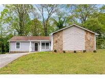 Charming single-story home featuring stone accents, light gray siding, and a welcoming front porch at 1181 Mannbrook Dr, Stone Mountain, GA 30083