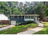 Charming home featuring a blue painted brick, white trim, and lush landscaping at 1907 Shalimar Ne Dr, Atlanta, GA 30345