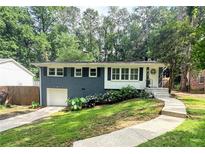 Charming one-story home featuring a combination of brick and white wood with inviting curb appeal and a lovely landscape at 1907 Shalimar Ne Dr, Atlanta, GA 30345