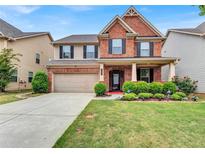 Inviting two-story home featuring a well-manicured lawn and a brick facade, creating a charming curb appeal at 3259 Baylor Cir, Mcdonough, GA 30253