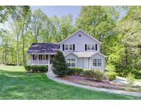 Charming two-story home with a landscaped yard, inviting front porch, and mature trees at 619 Stoney Creek Rd, Woodstock, GA 30188