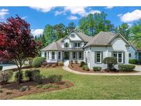 Charming two-story brick home with a well-manicured lawn and lush landscaping at 1749 Patriots Nw Way, Kennesaw, GA 30152